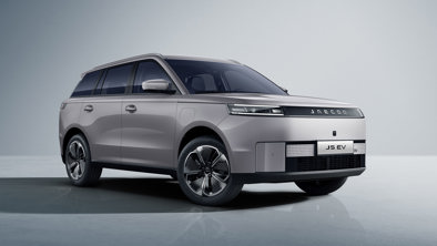 En sølvfarvet Jaecoo J5 EV SUV er parkeret i et veloplyst studie med en ensfarvet baggrund.